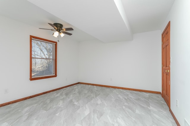 empty room featuring visible vents, a ceiling fan, and baseboards