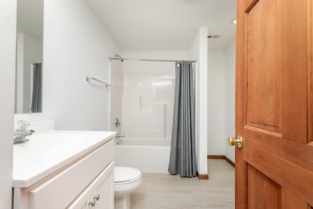 bathroom with vanity, toilet, visible vents, and shower / bath combo with shower curtain