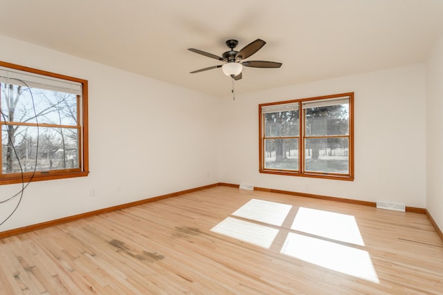 unfurnished room featuring visible vents, a ceiling fan, baseboards, and wood finished floors