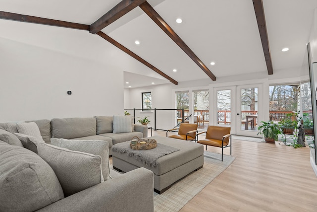 living area with light wood-type flooring, plenty of natural light, beam ceiling, and french doors