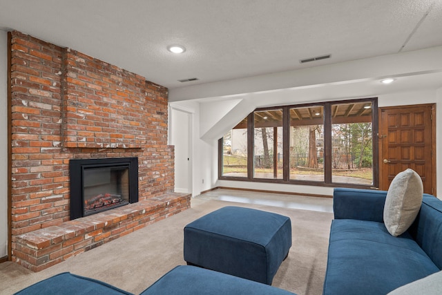 living area with a brick fireplace, visible vents, a textured ceiling, and carpet flooring