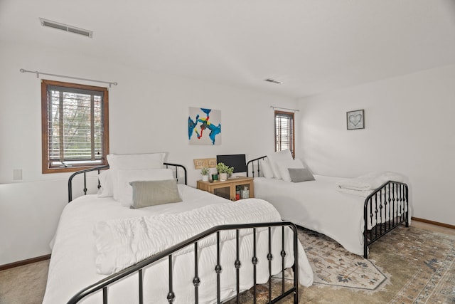 bedroom with multiple windows, visible vents, and baseboards