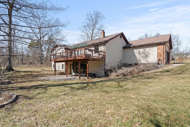 back of property featuring a patio area, a yard, a chimney, and a wooden deck