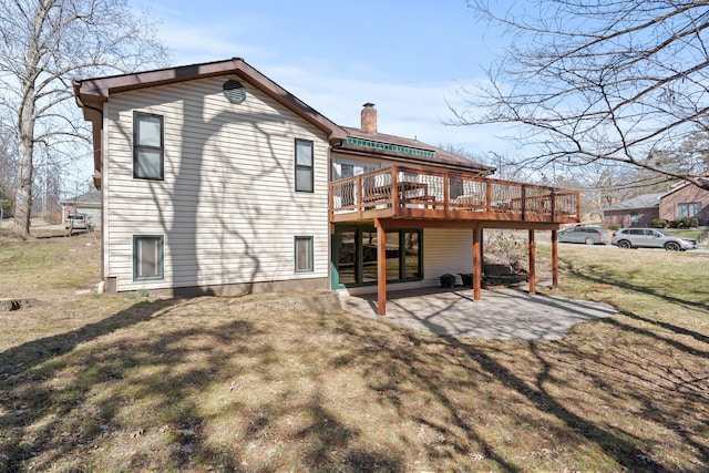 rear view of property with a yard, a chimney, a deck, and a patio