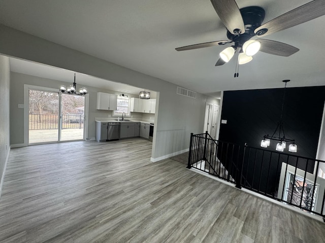 living room with sink, ceiling fan with notable chandelier, and light hardwood / wood-style flooring