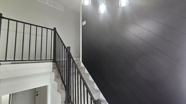 stairway with carpet and wooden walls