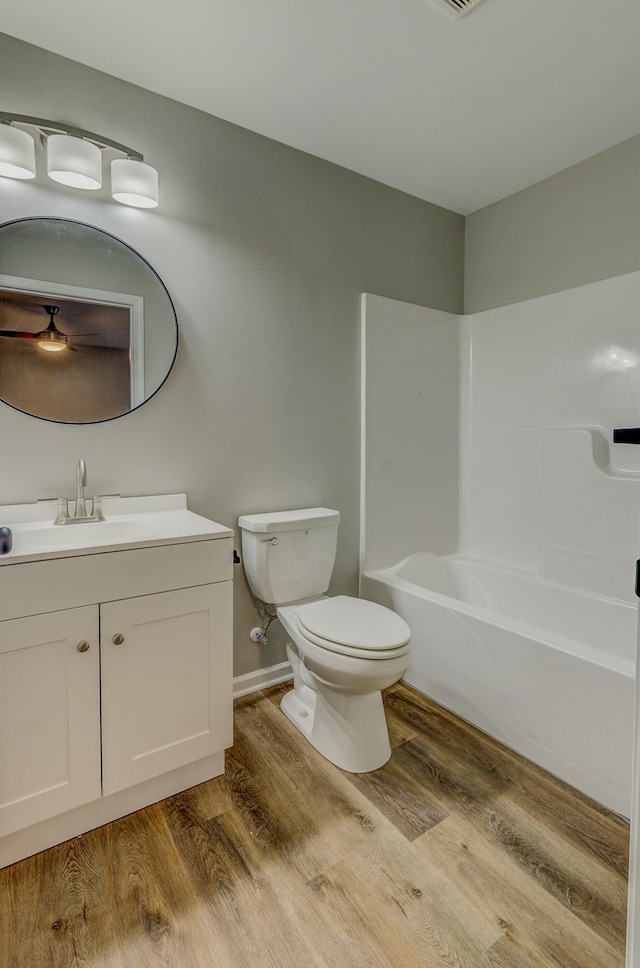 full bathroom with vanity, hardwood / wood-style floors, shower / tub combination, and toilet