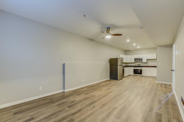 unfurnished living room featuring ceiling fan and light wood-type flooring