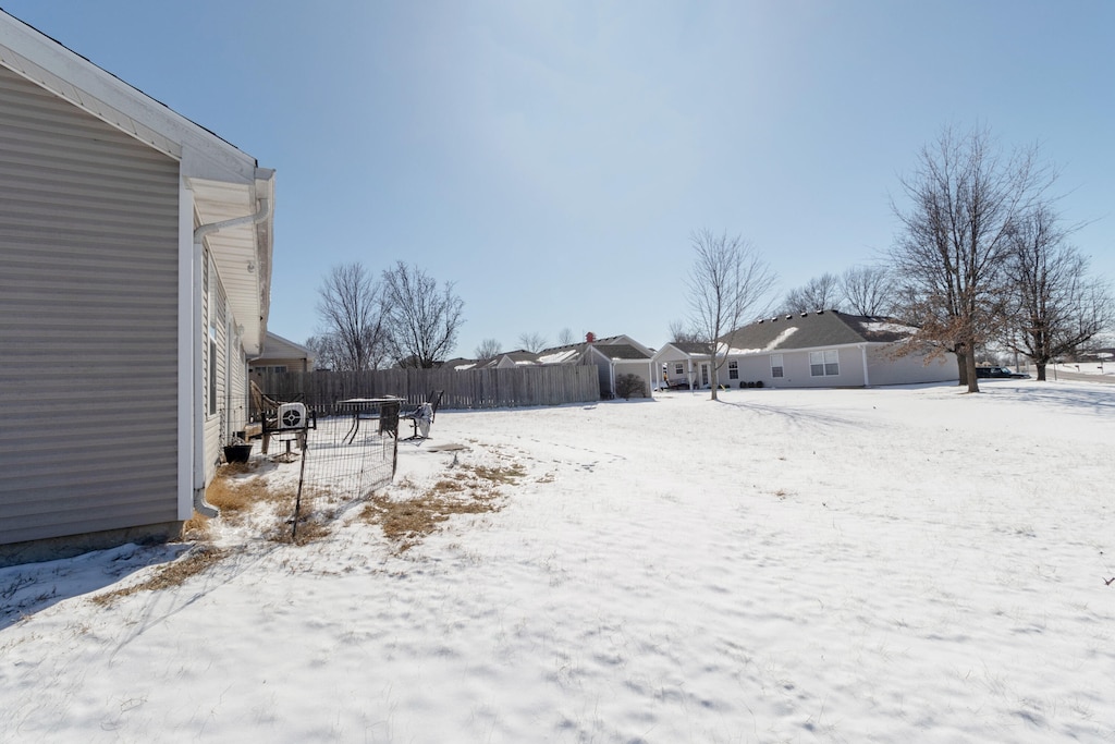 snowy yard featuring fence