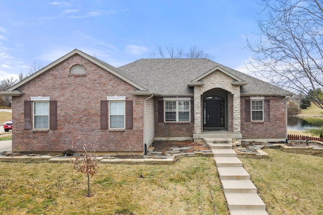 view of front of house with a front yard and a water view