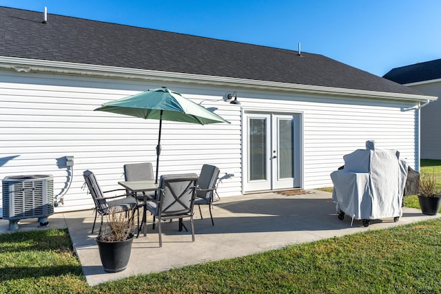 rear view of property featuring a yard, central AC, french doors, and a patio area