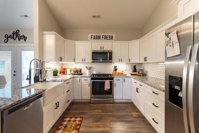 kitchen featuring appliances with stainless steel finishes, light stone countertops, and white cabinets