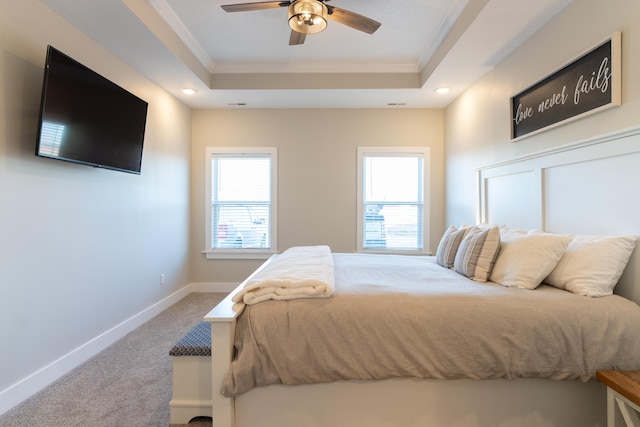 carpeted bedroom with crown molding, ceiling fan, and a tray ceiling