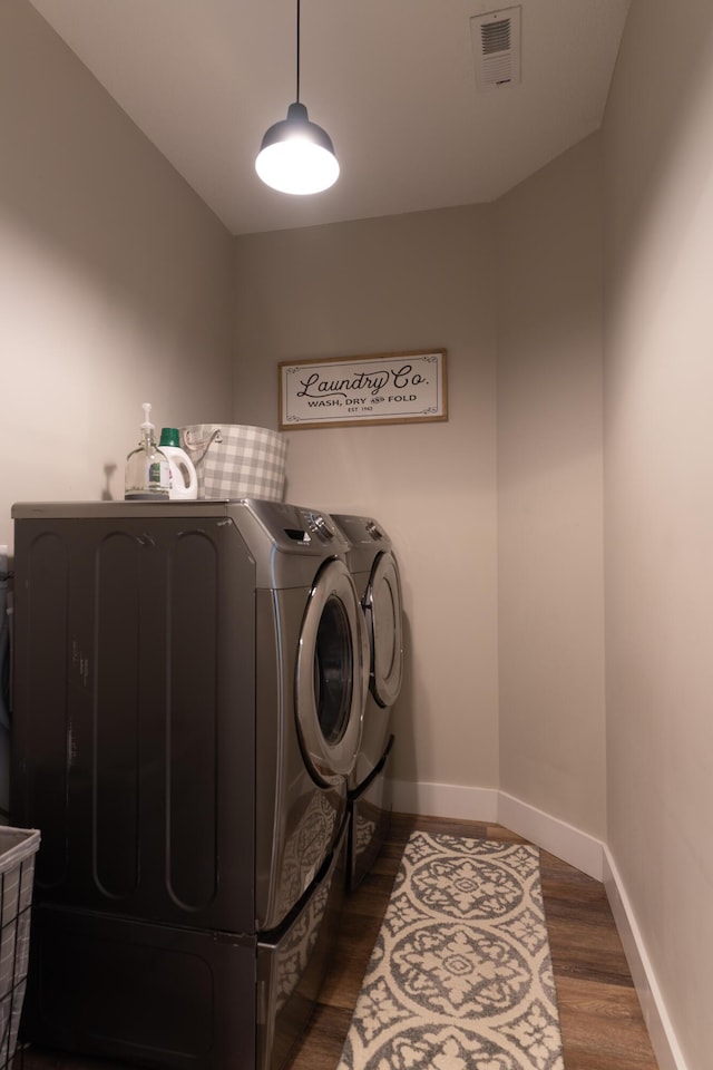 washroom featuring dark wood-type flooring and independent washer and dryer