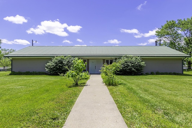 ranch-style house featuring metal roof and a front lawn