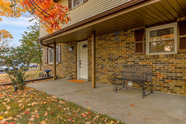 property entrance with a patio area and brick siding