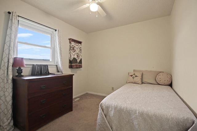 carpeted bedroom featuring a textured ceiling, a ceiling fan, and baseboards