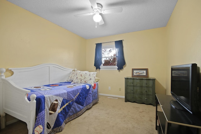 carpeted bedroom with ceiling fan, baseboards, and a textured ceiling