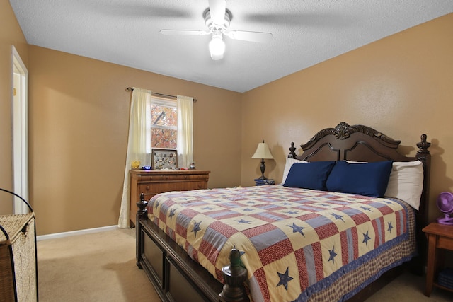 bedroom featuring light carpet, ceiling fan, a textured ceiling, and baseboards