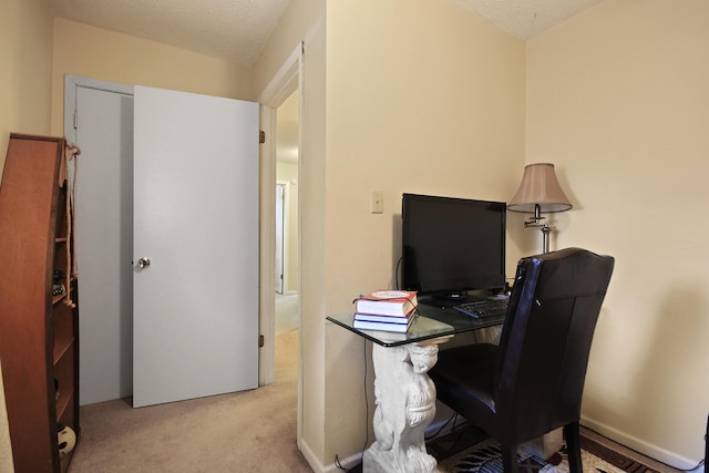 carpeted office featuring a textured ceiling