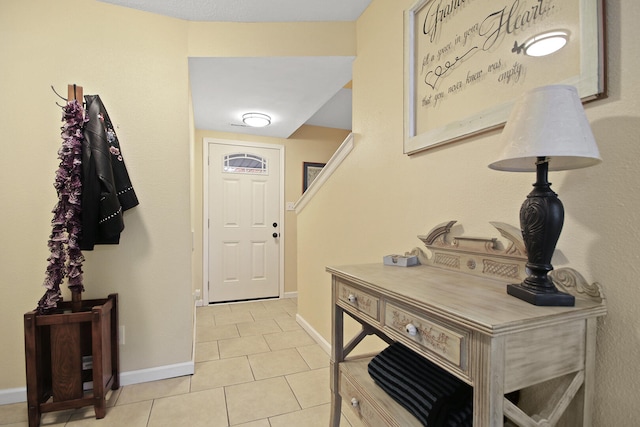 foyer entrance with light tile patterned flooring and baseboards