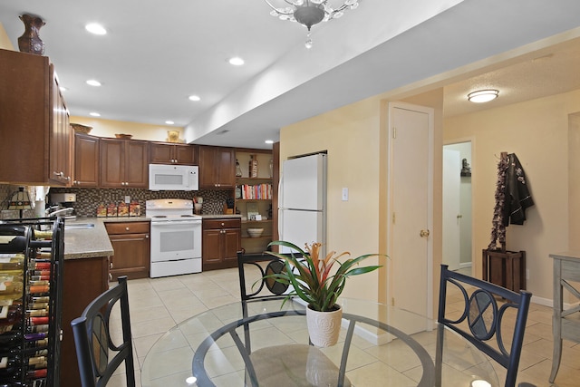 kitchen with light tile patterned flooring, recessed lighting, white appliances, baseboards, and tasteful backsplash