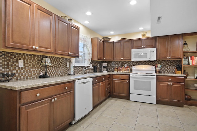 kitchen with white appliances, tasteful backsplash, light tile patterned floors, visible vents, and a sink