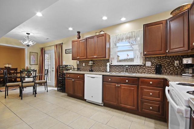 kitchen with white appliances, decorative backsplash, light countertops, a sink, and recessed lighting