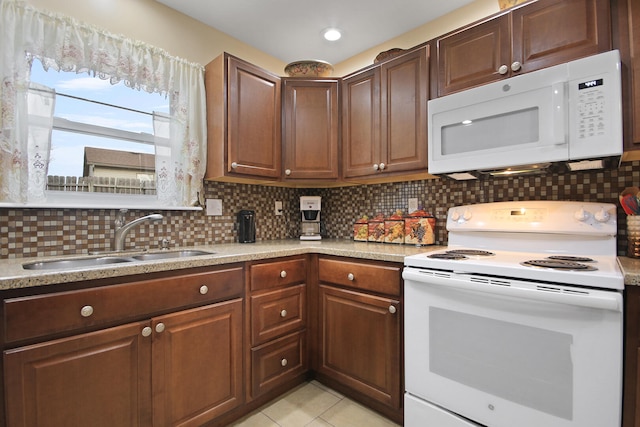 kitchen with white appliances, light tile patterned floors, a sink, light countertops, and backsplash