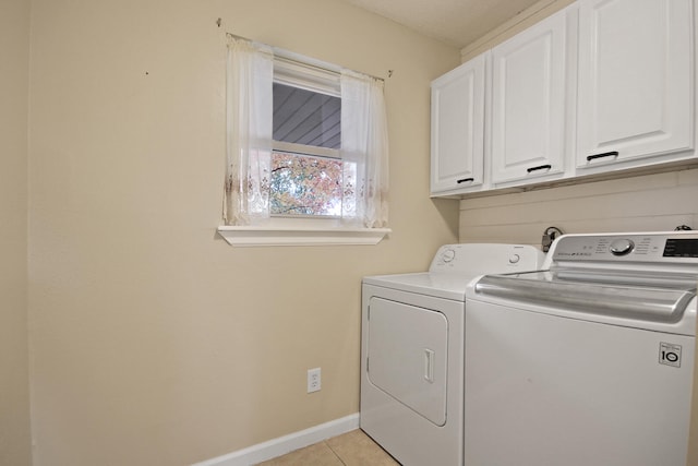 laundry room featuring cabinet space, light tile patterned floors, baseboards, and separate washer and dryer