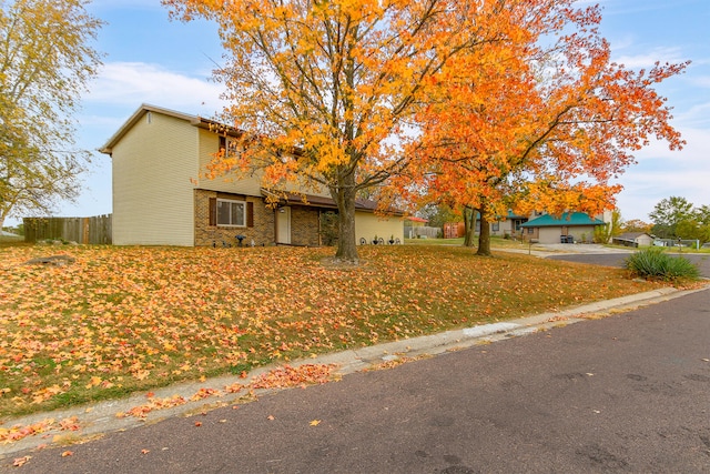 view of front of house featuring fence and brick siding