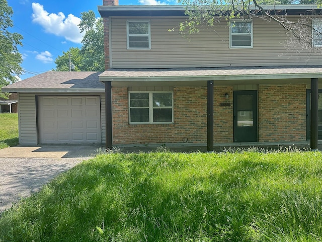 view of property with a garage and a front lawn