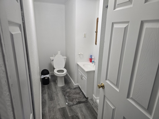 bathroom with vanity, toilet, and hardwood / wood-style floors