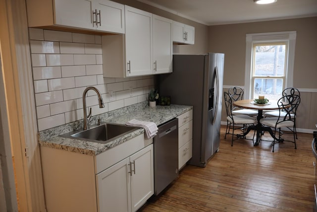 kitchen featuring appliances with stainless steel finishes, sink, hardwood / wood-style floors, and white cabinets