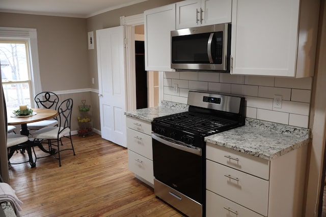 kitchen with white cabinetry, light hardwood / wood-style floors, and appliances with stainless steel finishes