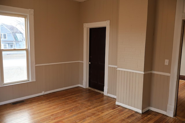 spare room featuring hardwood / wood-style floors and a healthy amount of sunlight