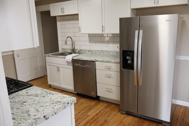 kitchen featuring light wood-type flooring, appliances with stainless steel finishes, sink, and white cabinets