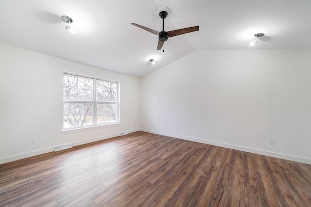 empty room featuring lofted ceiling, dark wood-type flooring, and ceiling fan