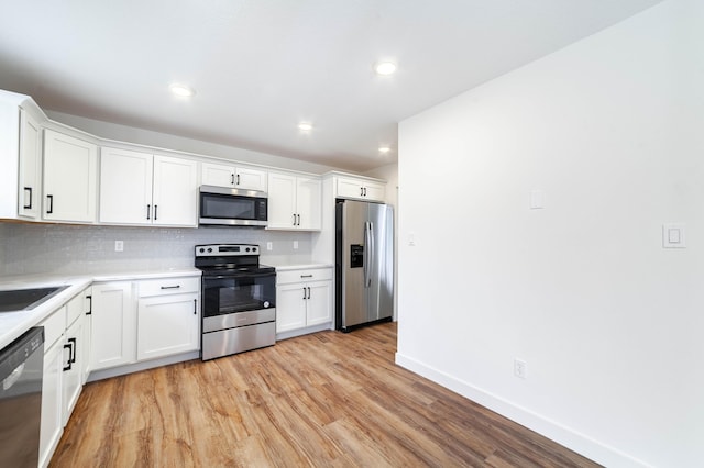 kitchen with white cabinetry, appliances with stainless steel finishes, and backsplash