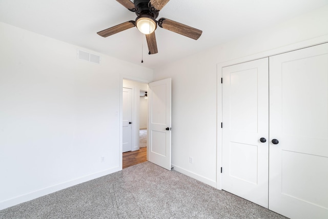 unfurnished bedroom featuring ceiling fan, a closet, and light carpet