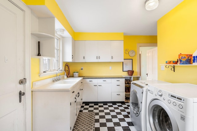 clothes washing area featuring cabinets, independent washer and dryer, and sink