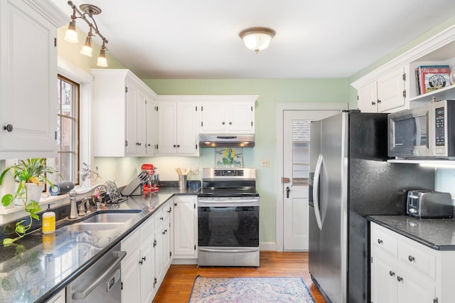 kitchen with white cabinetry, appliances with stainless steel finishes, sink, and light hardwood / wood-style flooring