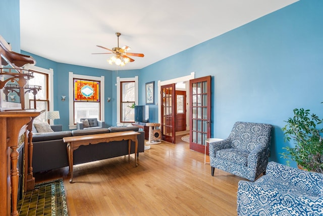 sitting room with hardwood / wood-style flooring, ceiling fan, and french doors