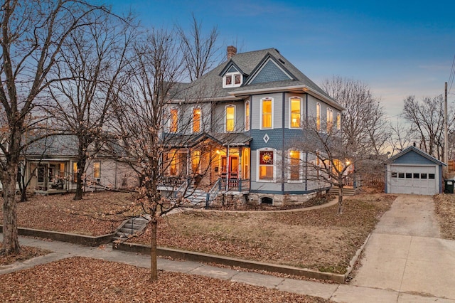 victorian home with a garage and an outdoor structure