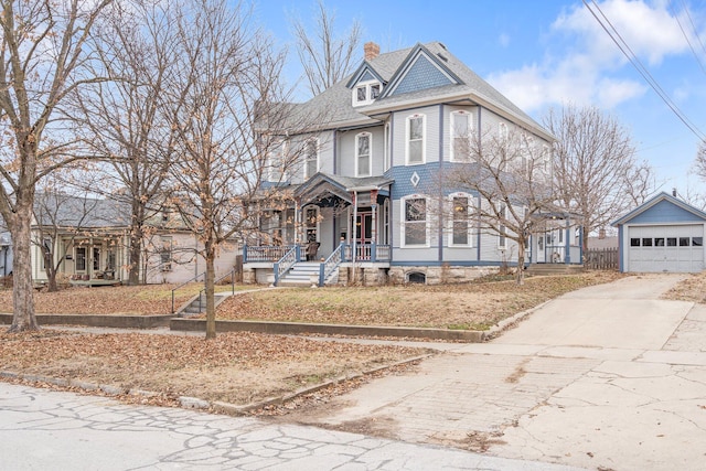 victorian house with a garage, an outdoor structure, and covered porch