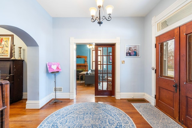 entryway with an inviting chandelier, french doors, and hardwood / wood-style flooring