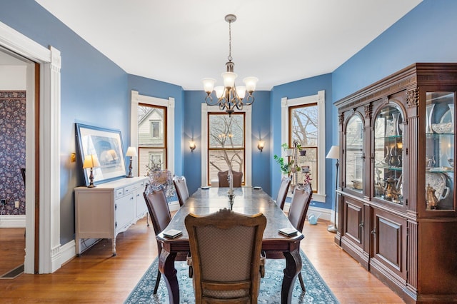 dining space with a wealth of natural light, a chandelier, and light wood-type flooring