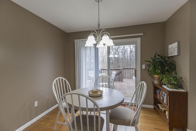 dining space with a notable chandelier and light hardwood / wood-style flooring