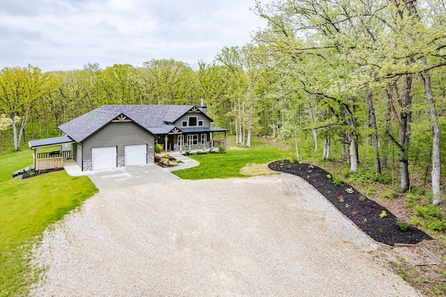 4503 E Mcgee Rd, Columbia, MO 65202 - view of front of home with a garage, a front lawn, gravel driveway, a porch, and a wooded view