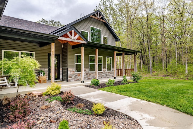 4503 E Mcgee Rd, Columbia, MO 65202 - craftsman-style house with stone siding, roof with shingles, covered porch, and a front yard